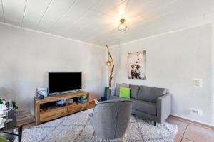 a living room with a couch and a tv at Cottage in Schlangenbad in Schlangenbad