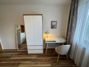 a room with a mirror and a desk and a chair at Pension Katharina im Solling in Holzminden