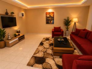 a living room with red furniture and a flat screen tv at appartement golf in Bamako