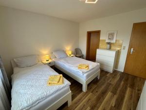 two beds in a small room with two lamps at Pension Katharina im Solling in Holzminden