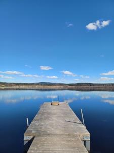 a dock on a lake with a blue sky at Det Gamla Postkontoret in Råda