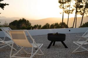 a couple of chairs and a grill and a fire pit at Finca La Oliveta Ronda in Ronda