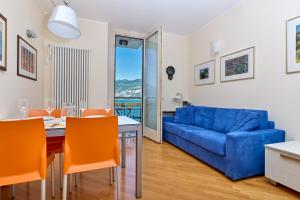 a living room with a table and a blue couch at The Lake Balcony by Gardenjoy in Brenzone sul Garda