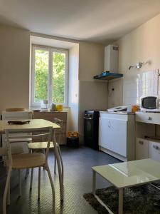 a kitchen with a table and a table and chairs at Joly Saint Sauveur in Villard-Saint-Sauveur