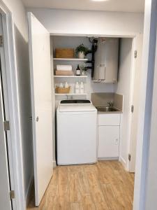 a small kitchen with a washer and a sink at Sundown terrace in North Fremantle