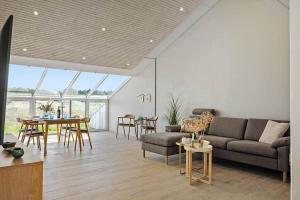a living room with a couch and a table at BL1001-Blokhus-Ferren-95 in Blokhus +13 photos