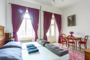 a bedroom with a bed with purple curtains and a table at Zámeček Rozkoš in Střížovice