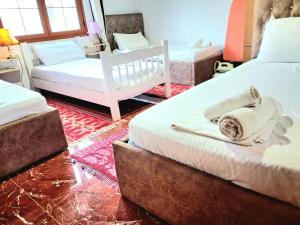 a bedroom with two beds with towels on them at Villa Rexho in Berat