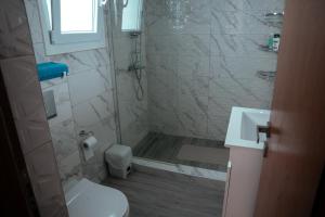 a bathroom with a shower and a toilet and a sink at Village Bliss in Kardamaina +3 photos