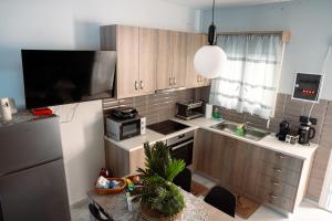 a kitchen with wooden cabinets and a table with a sink at Village Bliss in Kardamaina