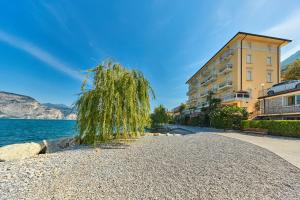 a tree on a gravel road next to a building at The Lake Balcony by Gardenjoy in Brenzone sul Garda