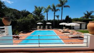 a swimming pool with lounge chairs and umbrellas at Villa Bruno in Modica