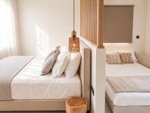 a bedroom with two beds with white sheets and pillows at Milea amare Suites in Adamantas +54 photos