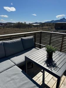 a couch sitting on a deck with a table at Apartment Lofoten, Leknes in Leknes