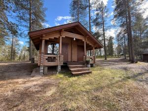 a small cabin in the middle of a forest at Kolmiloukon leirintämökit in Taivalkoski