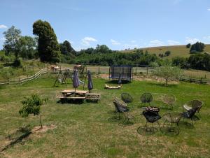 a group of chairs and a picnic table in a field at Ferme Équestre Equi'Cantal in Montboudif