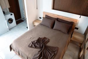 a bedroom with a large bed with brown sheets and pillows at Village Bliss in Kardamaina