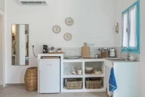 a kitchen with a white refrigerator and a sink at Sokaki Patmos in Skala