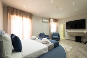 a bedroom with a large bed and two blue chairs at 3 torri GATEWAY in Maddaloni