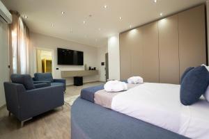 a bedroom with two beds and a couch and a tv at 3 torri GATEWAY in Maddaloni