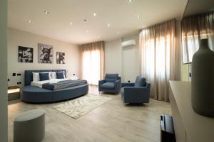 a bedroom with a bed and two blue chairs at 3 torri GATEWAY in Maddaloni +89 photos