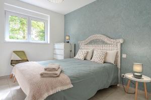 a bedroom with a bed with a white headboard at LE JOLI BOIS in Colroy-la-Roche