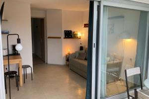 a living room with a couch and a table at Pool and beach studio in Quiberon