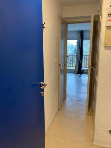 a blue door leading into a room with a balcony at Pool and beach studio in Quiberon