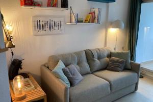 a living room with a couch with pillows on it at Pool and beach studio in Quiberon +11 photos