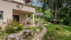 a backyard with a stone wall and a house at LE JOLI BOIS in Colroy-la-Roche