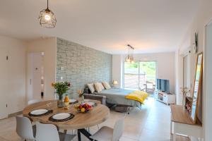 a living room with a bed and a dining table at LE JOLI BOIS in Colroy-la-Roche