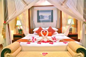 een slaapkamer met een groot bed met bloemen erop bij Oriental Siam Resort - SHA Extra Plus Certified in Chiang Mai