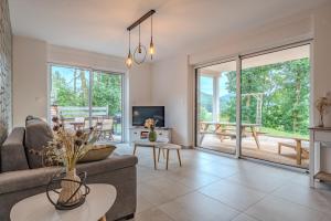 a living room with a couch and a table at LE JOLI BOIS in Colroy-la-Roche