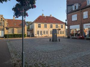 a cobblestone street in a town with buildings at Stubbekøbing City View Stopover in Stubbekøbing