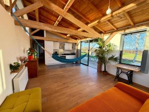 a living room with a hammock in a house at Gîte de groupe et charmant cottage L'Agnel in Domaize