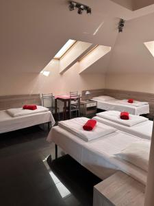 a room with four beds and a table and chairs at Żywiec CENTRUM Apartamenty z aneksem kuchennym & łazienką in Żywiec