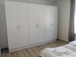 a white bedroom with white cabinets and a bed at Stubbekøbing City View Stopover in Stubbekøbing