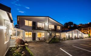 a house with a staircase in a parking lot at Beechwood Boutique Accommodation in Dunedin