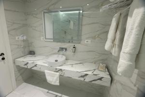 a white bathroom with a sink and a mirror at Metro Hotel Terminal in Tirana +75 photos