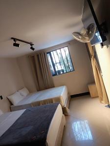 a hotel room with two beds and a window at Hotel Golden 70 in Medellín +18 photos