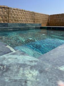 a pool of water in front of a wooden fence at Riad Nirvana in Marrakesh