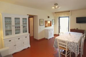 a dining room with a table and a white hutch at Agriturismo Peretti in Fonteblanda