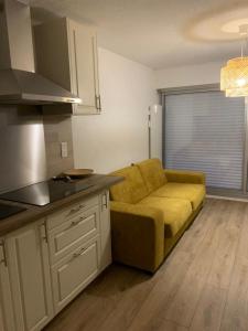 a living room with a yellow couch in a kitchen at Apartment with pool and beach access 2 No 31 in Quiberon