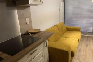 a kitchen with a yellow chair next to a counter at Apartment with pool and beach access 2 No 31 in Quiberon