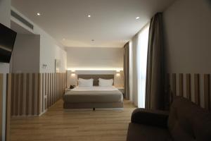 a bedroom with a bed and a couch at Metro Hotel Terminal in Tirana