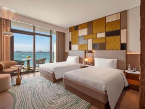 a hotel room with two beds and a view of the ocean at SO Ras Al Khaimah Hotel & Resort-Ultra All Inclusive in Ras al Khaimah +157 photos