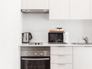 a kitchen with a stove and a microwave at LSA Castelo S Jorge by Numa in Lisbon