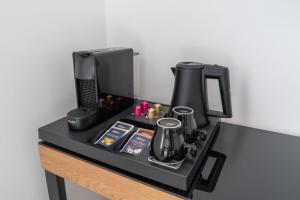 a black counter with a coffee maker and a coffee pot at Villa Vaicun - Boutique Rooms in Lörrach +75 photos