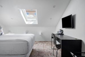 ein Schlafzimmer mit Bett, Schreibtisch und Fernseher in der Unterkunft Hotel Hötorget, BW Signature Collection in Stockholm