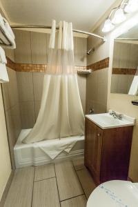 uma casa de banho com um chuveiro, uma banheira e um lavatório. em Budget Inn of America em Medford